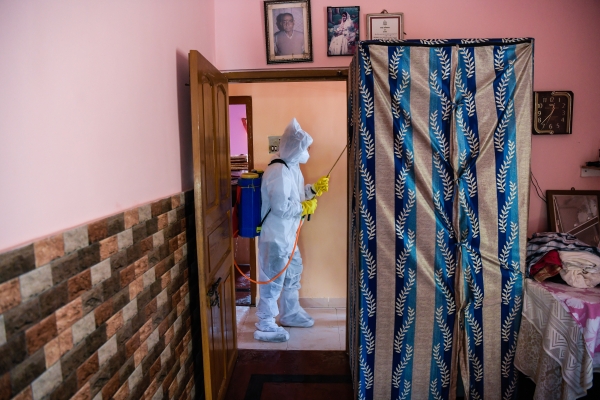 Man in hazmat suit cleaning apartment