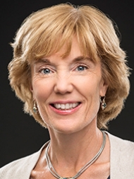 Headshot of Laura Perna, wearing a white shirt and smiling