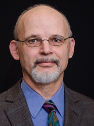 Headshot of Simon Richter, wearing a suit and tie