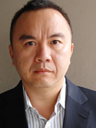 Headshot of Ken Lum, wearing a dark suit