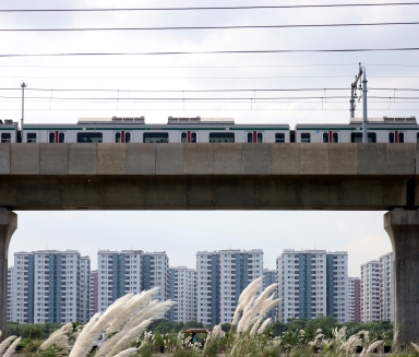 View of train passing in front of housing blocks